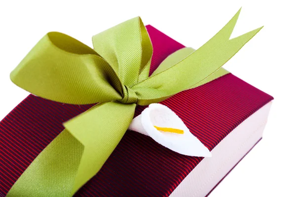 Beyaz zemin üzerine yeşil bir yay ile koyu kırmızı hediye kutusu — Stok fotoğraf