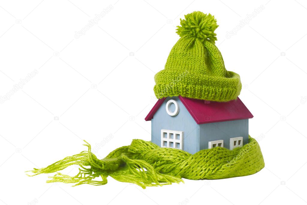Conceptual Miniature Model House With Green Woolen hat and scarf, Isolated On White Background
