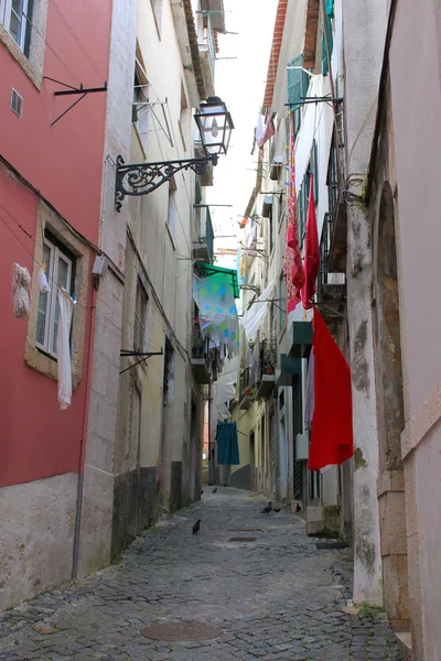 Arnavut kaldırımlı alfama Çamaşırhane asılı ile sokak — Stok fotoğraf