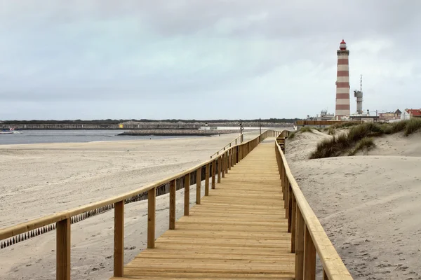 Boardwalk in Praia Barra with lighthouse — Stock Photo, Image