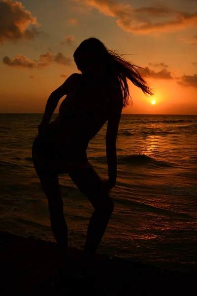 Un couple sur la plage au coucher du soleil — Photo