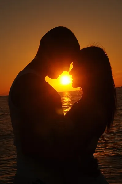 Een paar op het strand bij zonsondergang — Stockfoto