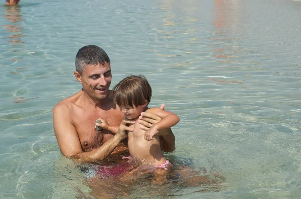 Vater und Sohn lächeln am Strand — Stockfoto