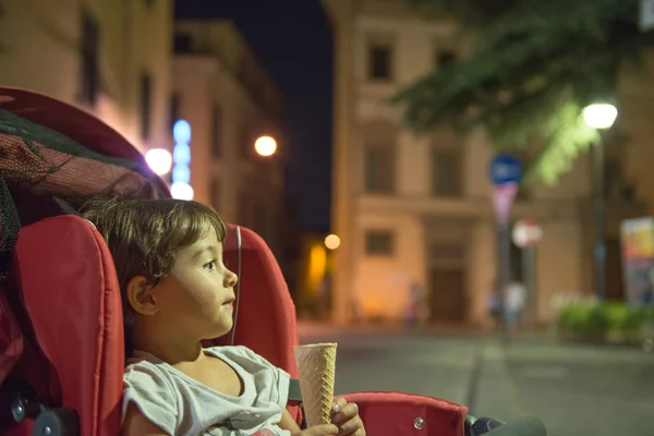 Dziecko jedzenie lodów w mieście w nocy - Włochy — Zdjęcie stockowe