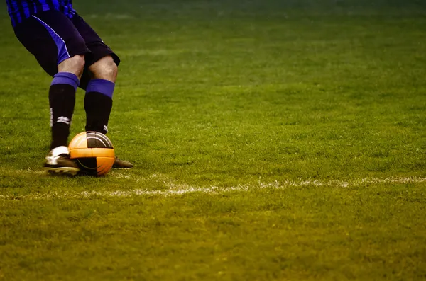 bir futbol maçı sırasında topu tekmeleme