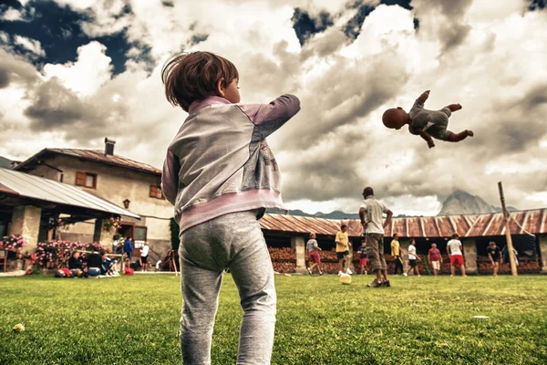 Baby throwing a Doll in the air at a park outdoor — Stock Photo, Image