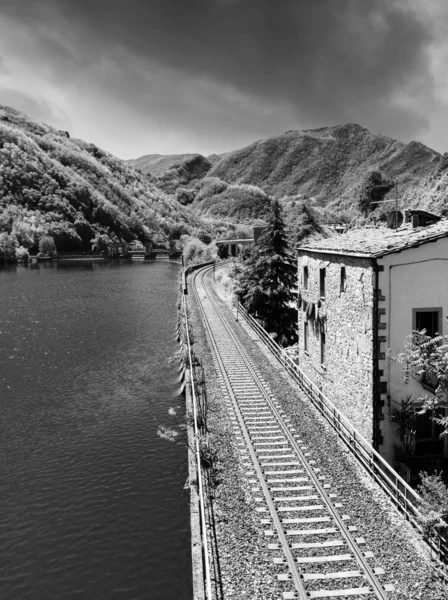 Spoorlijn met rivier, sky en vegetatie in Toscane — Stockfoto