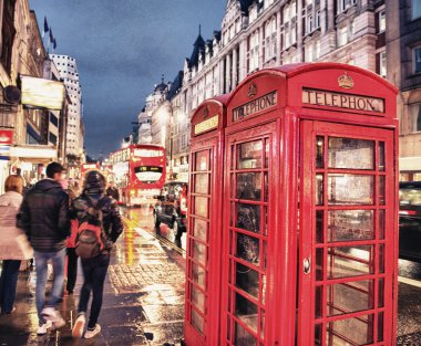 Londra'da gece kalabalık bir caddede kırmızı telefon kulübesi