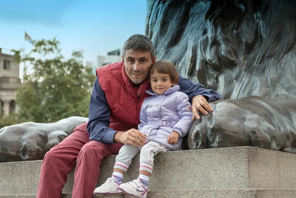 Baby with father playing at the base of Nelson Column in Trafalg — Stock Photo, Image
