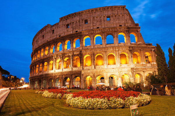 Beautiful view of Colosseum at sunset with flowerbed in foreground - Rome - Italy