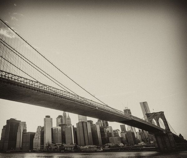 Upward view of Brooklyn Bridge at Sunset with Manhattan Skyline - USA