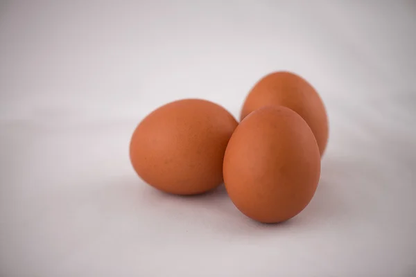 Grupper av tre egg på hvit bakgrunn – stockfoto