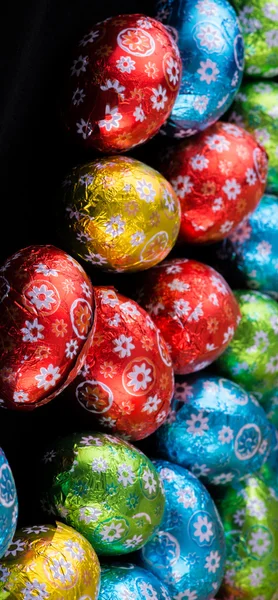 Hermosos coloridos pequeños huevos de Pascua sobre fondo negro — Foto de Stock