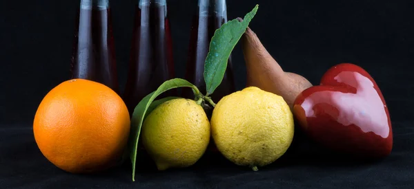 Помаранчевий, лимон і перо на чорному тлі — стокове фото