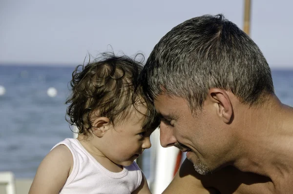 Батько і дочка, дивлячись один одного на пляжі — стокове фото