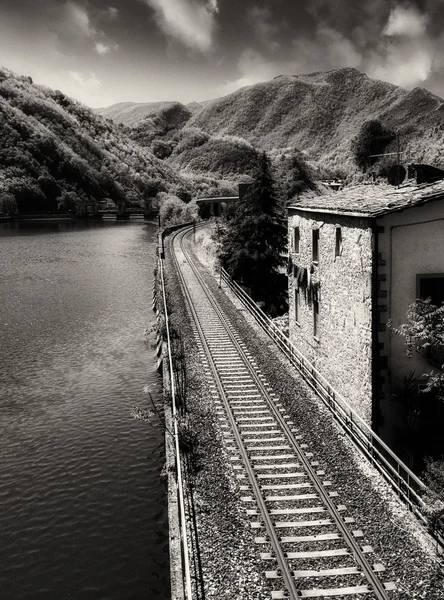 Spoorlijn met rivier, sky en vegetatie in Toscane — Stockfoto