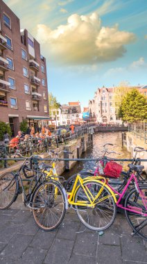 Amsterdam. Kanal üzerinde renkli sarı ve pembe Bisiklet