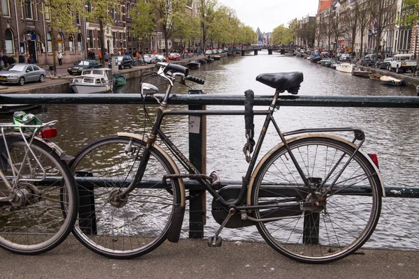 Amsterdam, Nederländerna. färgglada cykel över en bro och staden kanaler — Stockfoto