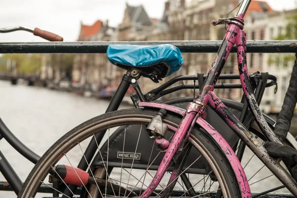 Amsterdam, Nederländerna. färgglada cykel över en bro och staden kanaler — Stockfoto