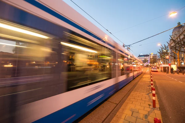 Amsterdam. tram versnellen bij zonsondergang in de straten van stad — Stockfoto