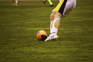 bir futbol maçı sırasında topu tekmeleme