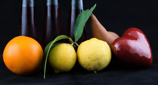 Помаранчевий, лимон і перо на чорному тлі — стокове фото