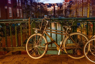 amsterdam, netherlan kanalları üzerinde bir köprü astar bisikletler