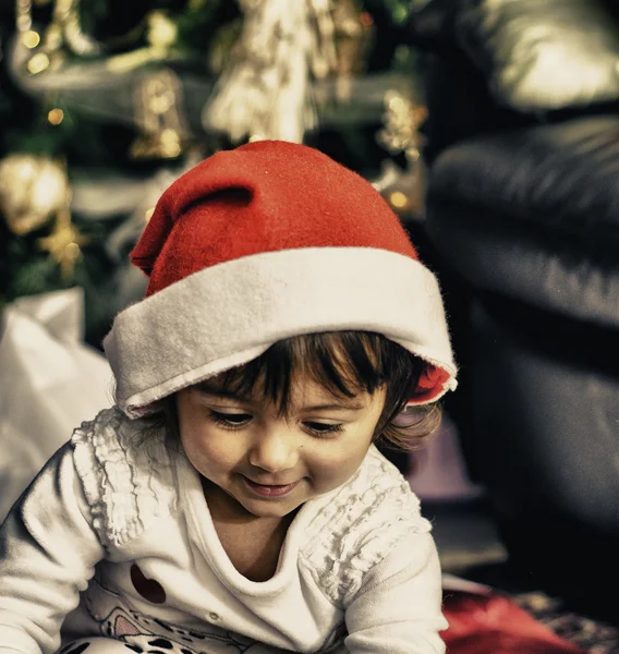 Baby mit Weihnachtsmütze spielt drinnen — Stockfoto