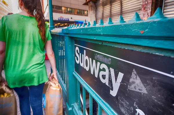 Meisje doorgeven voor een ingang van de metro in new york city — Stockfoto