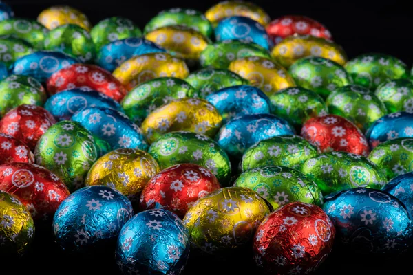 Hermosos coloridos pequeños huevos de Pascua sobre fondo negro — Foto de Stock