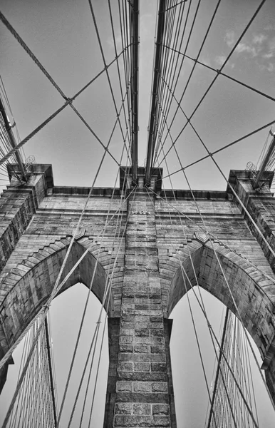 El puente de Brooklyn al atardecer. Vista hacia arriba del pilón y los cables — Foto de Stock