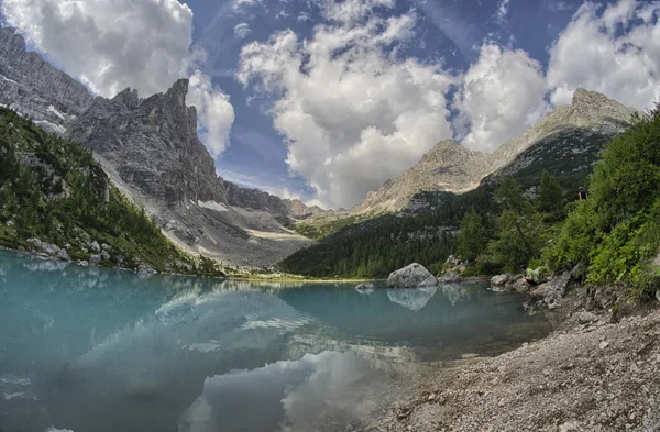 Maravilloso lago de montaña de color azul con vegetación y picos —  Fotos de Stock