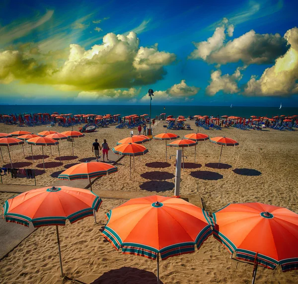 Orangefarbene Sonnenschirme am Meer bei Sonnenuntergang — Stockfoto