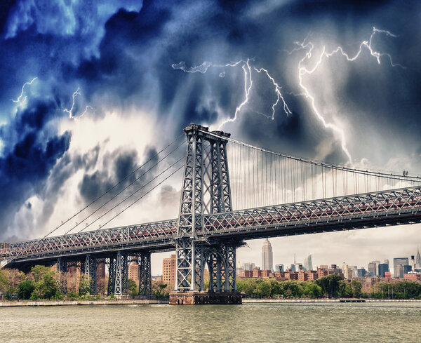 Storm above Manhattan Bridge structure and East River - New York.