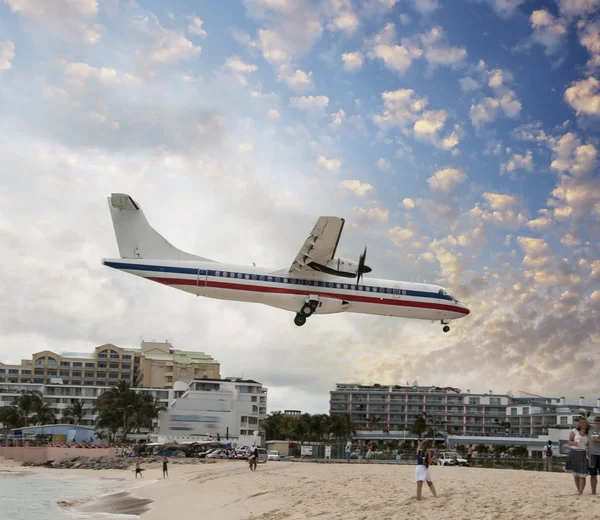 Airplane landing just above the beach at sunset — Stock Photo, Image