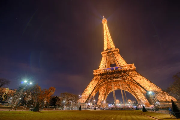 Paris - 30 Kasım: turist yürümek Eyfel Kulesi'nin altında gece karanlığında, n — Stok fotoğraf