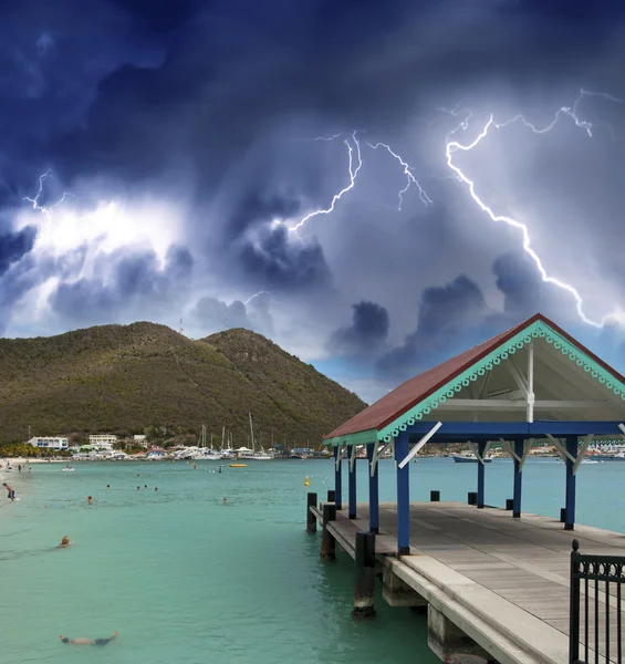 Thunderstorm over beautiful beach with jetty over water — Stock Photo, Image
