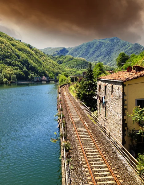 Spoorlijn met rivier, sky en vegetatie in Toscane — Stockfoto