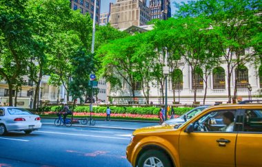 Yellow cabs speeding up in front of New York Public Library clipart