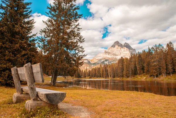 Banco solitario con hermosa vista al lago y a la montaña —  Fotos de Stock