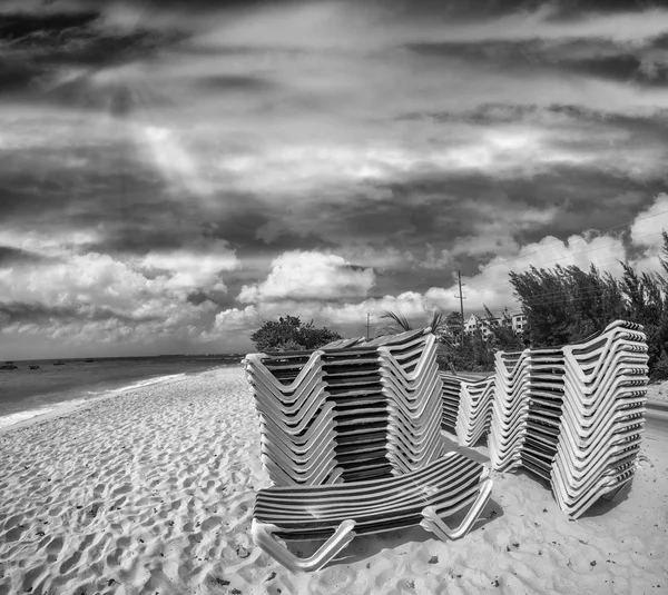 Deck chairs stacked on a beautiful beach — Stock Photo, Image