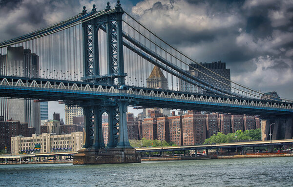 Side view of Manhattan Bridge structure and New York buildings.