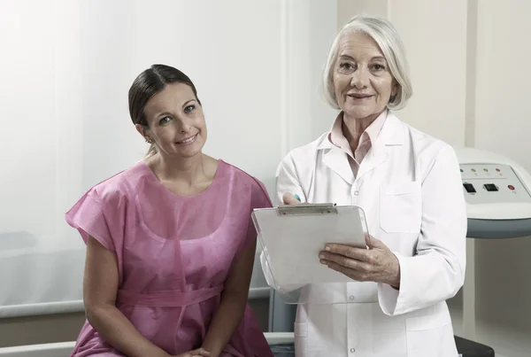 Doctora experta mostrando exámenes médicos a mujer feliz en los años 40 — Foto de Stock