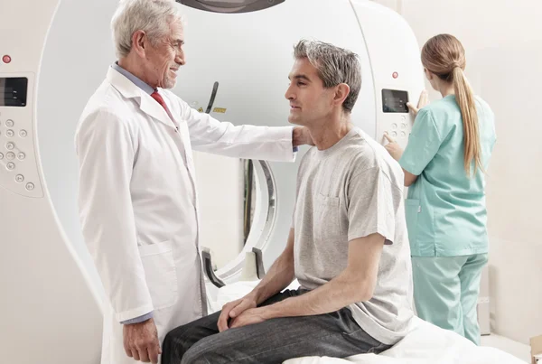 Senior mannelijke arts ct scanner examen uit te leggen aan de mens in 40s. Fem — Stockfoto