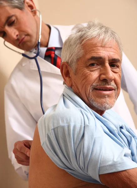 Médico varón examinando paciente anciano en el hospital —  Fotos de Stock