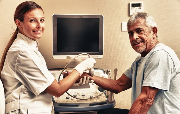 Mulher médico examinando paciente homem pulso com ultra-som — Fotografia de Stock