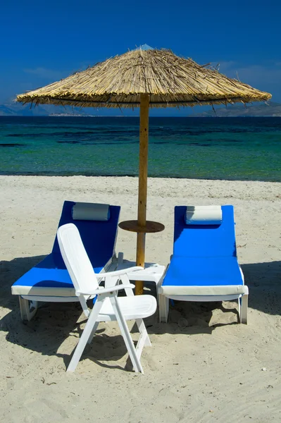 Sillas de playa con sombrillas de paja — Foto de Stock