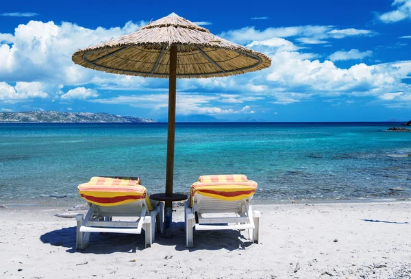 Beach umbrella and chairs on beach — Stock Photo, Image