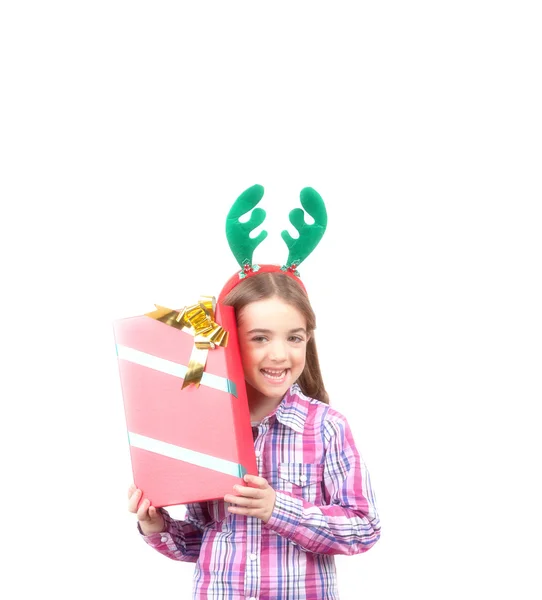 Счастливая девочка в оленьих рогах с рождественским подарком, это — стоковое фото