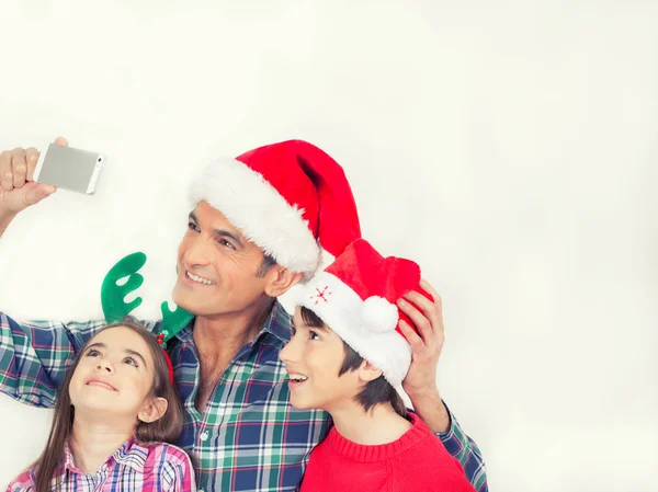 Отец с двумя детьми делает семейное рождественское селфи, изола — стоковое фото